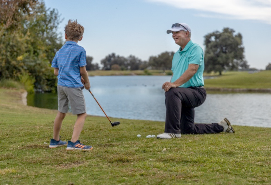 Image of Tom Ringer instructing a boy golfer